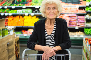 Content senior woman in the grocery store avoiding dementia outbursts in public